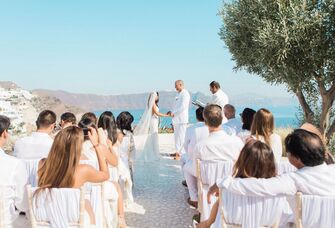 Guests wearing white during wedding ceremony