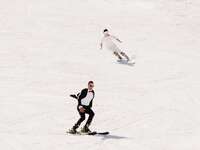 bride and groom skiing down the mountain in their wedding attire