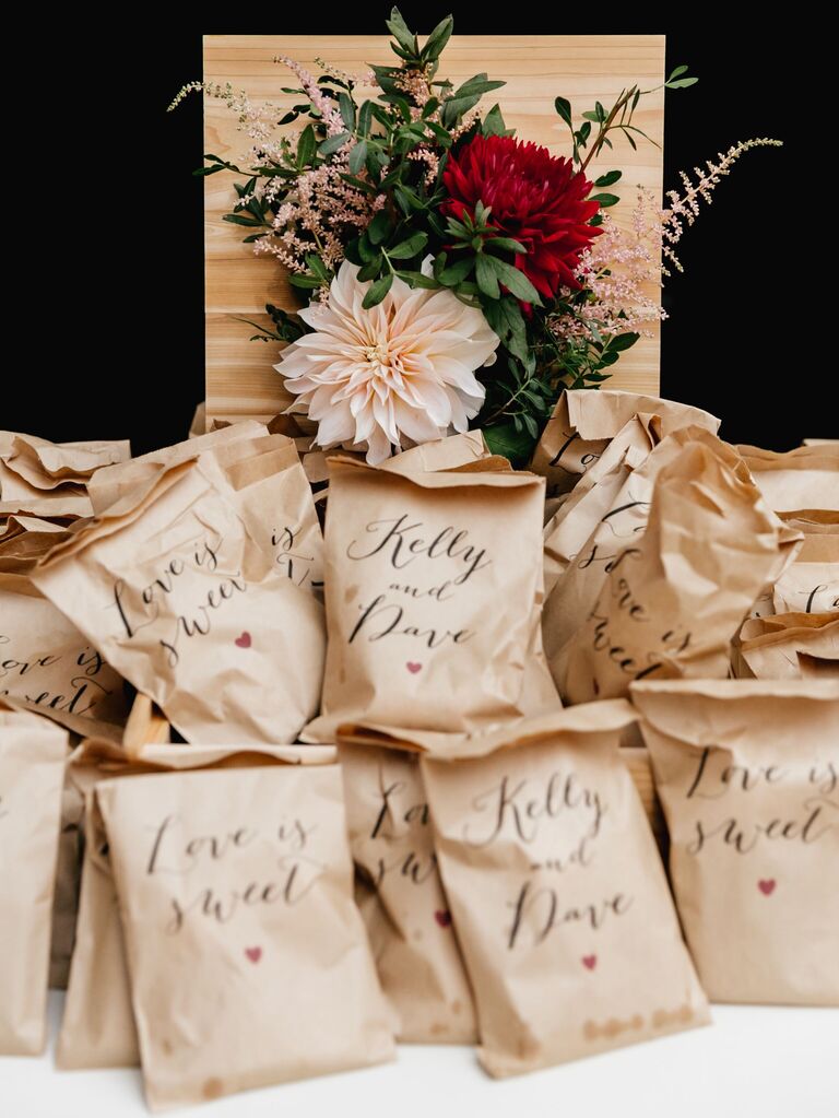 wedding favor display with treats in customized brown paper bags 