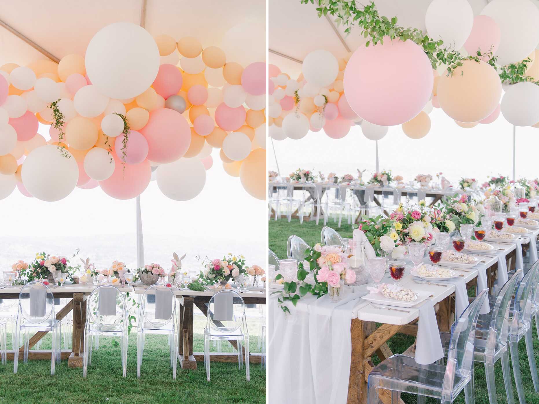 Pastel pink and white balloon garland hanging over long tables