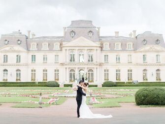 Couple embracing outside beautiful château-like venue