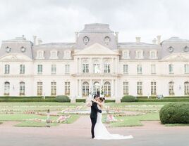 Couple embracing outside beautiful château-like venue
