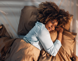 Woman laying in bed looking out window