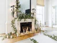 fireplace decorated with greenery and candles