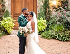 Groom in velvet green tux with bride wearing fit and flare gown with 1920s inspired headband