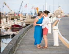 Couple holding hands on boardwalk in Massachusetts