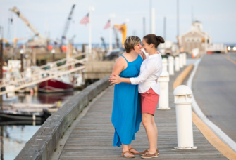 Couple holding hands on boardwalk in Massachusetts