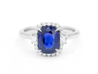 A sapphire engagement ring, the blue stone encircled by small diamonds.