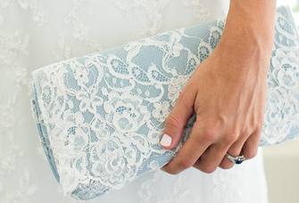 Bride holding a blue lace clutch