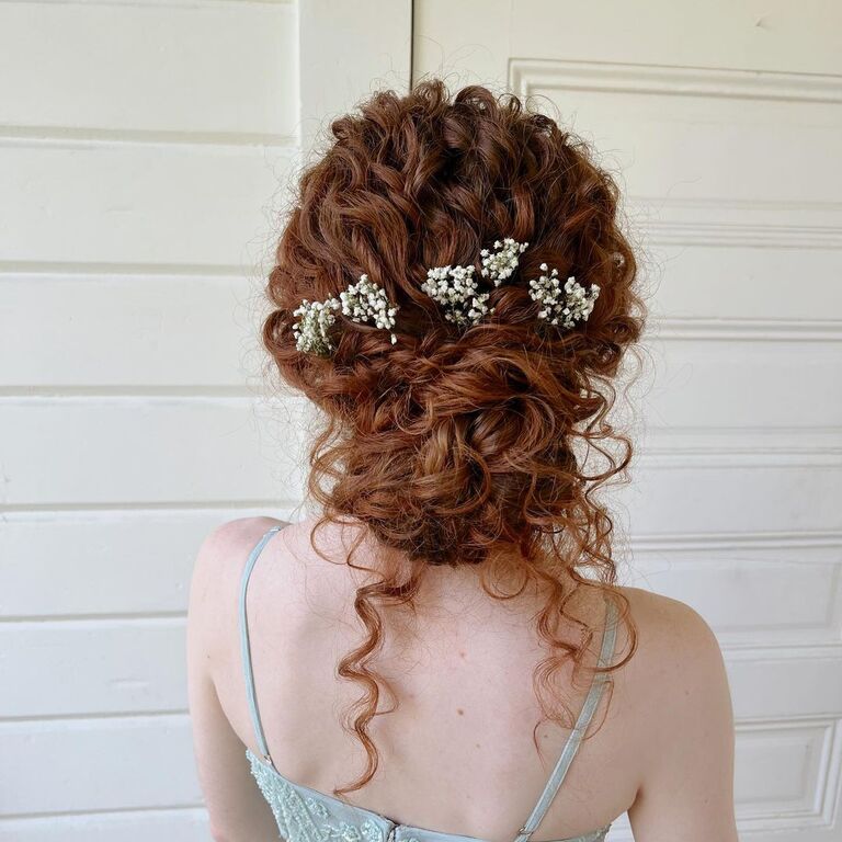 Updo with natural curls and floral accessories