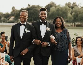 Parents walking son down the aisle 