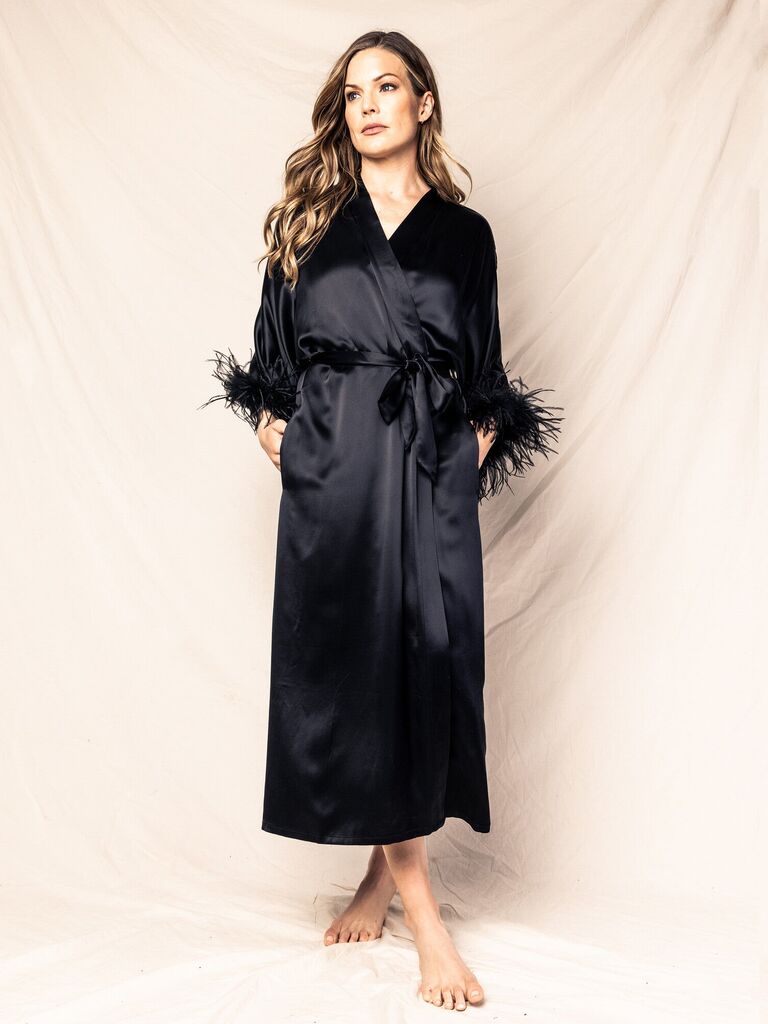 Model wearing a black bridal robe with a feather trim on each sleeve