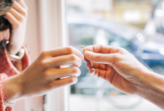 Two people holding gold engagement ring, where to shop for engagement rings in Jacksonville, Florida