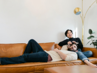 Couple laying on couch together laughing