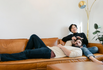 Couple laying on couch together laughing