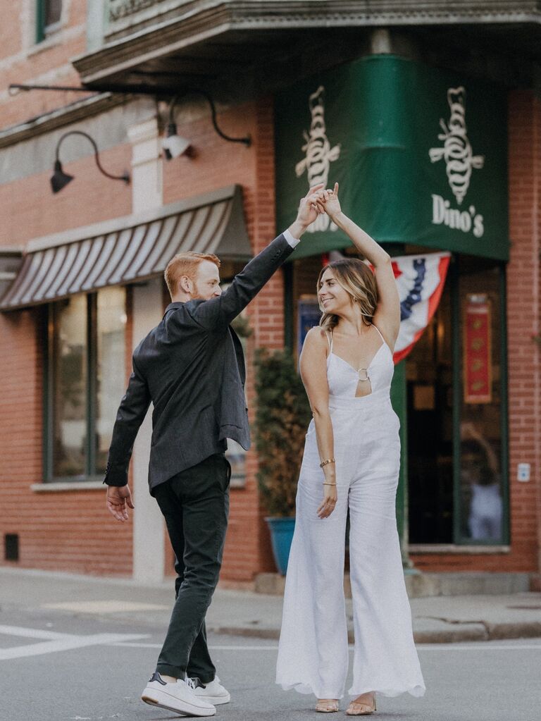 Couple dance in the street for their engagement photo session. 