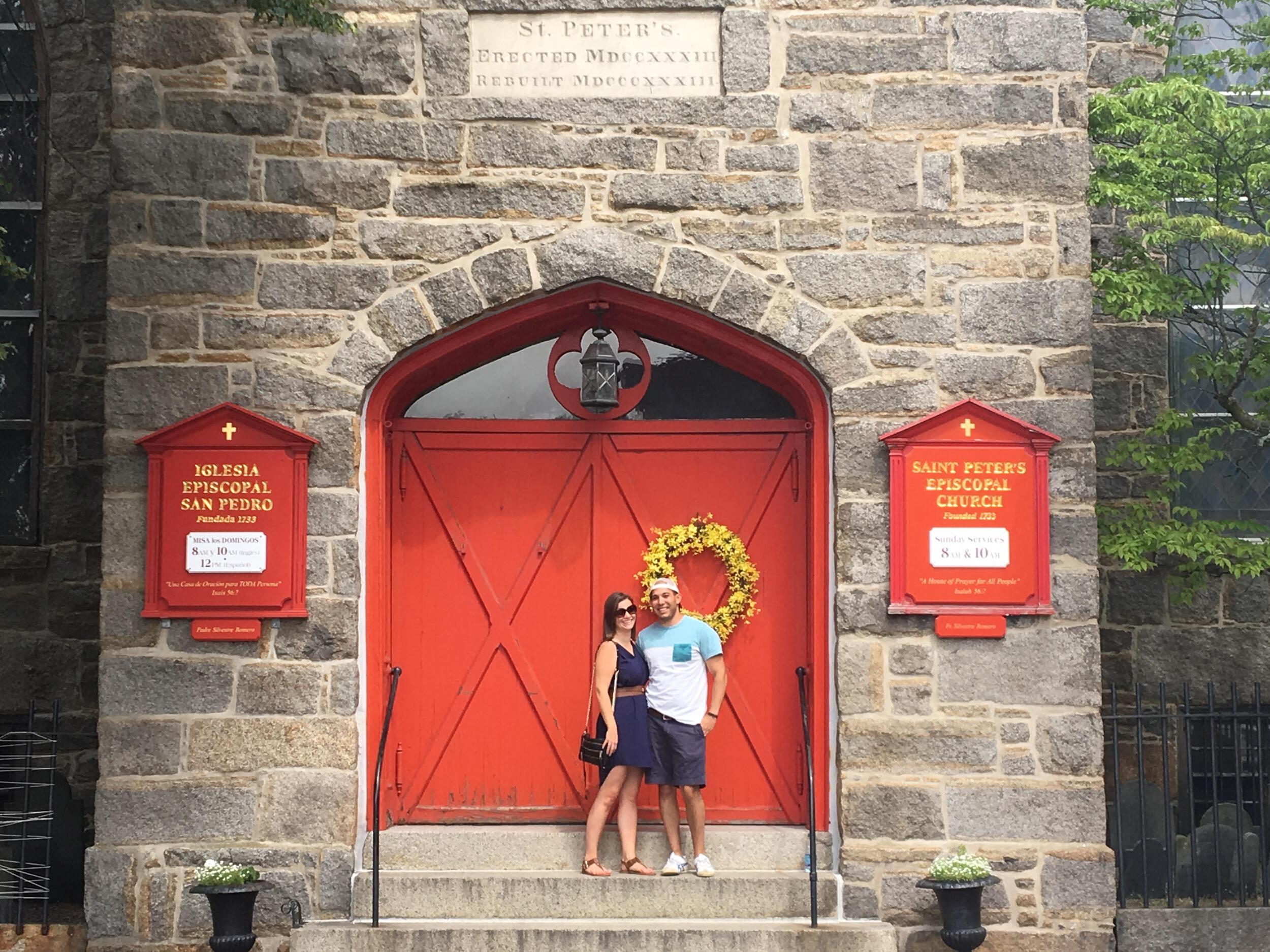 In Spring of 2017, we met while playing in a social  volleyball league . Our first date was a cooking class at the Cambridge Culinary Institute, where we spent the night laughing over salad spinners and mushy tomato soup. 

To the right is our first photo together during a day trip to Salem! Bonus points if you can find this building & red door during our wedding weekend. 