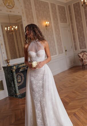 Charming dress featuring a soft mesh halter-neck top with sequin collar draping over a sweetheart corset and shaping a veil. The classic silhouette is outlined by draped mesh over the bodice. The dress itself is crafted from lightweight floral guipure, embellished with sequins.
