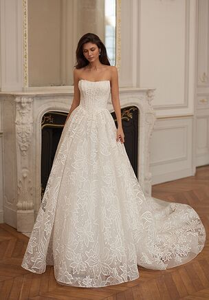 The Moonlight Collection J7007 wedding dress is an ethereal A-line gown in airy layers of tulle, featuring a strapless scoop neckline, beaded trim, and a flattering basque waist. Adorned with shimmering floral beading and finished with a voluminous skirt and chapel train, this ivory design delivers dreamy movement and radiant, romantic sparkle.