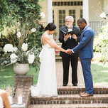 Couple with officiant during wedding ceremony.