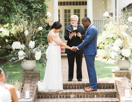 Couple with officiant during wedding ceremony.