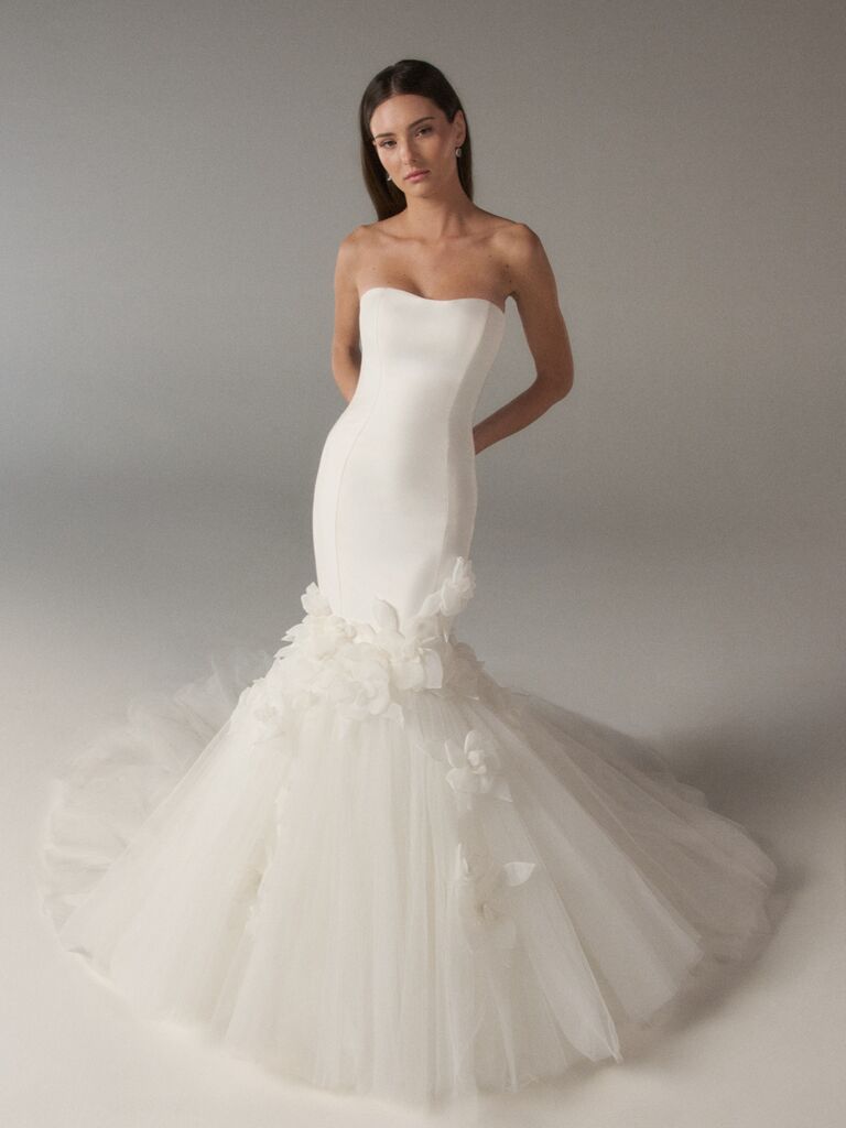 Clean, fitted mermaid Poeza wedding dress with simple bodice and flared tulle skirt with floral appliques