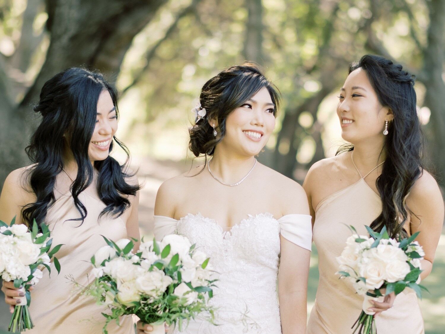 Bride and her bridesmaids smile for the camera. 