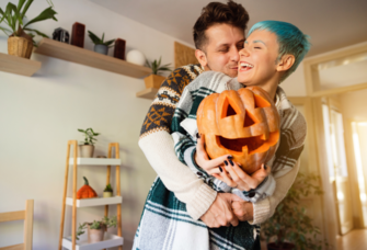 Cheerful couple with Jack O' Lantern pumpkins