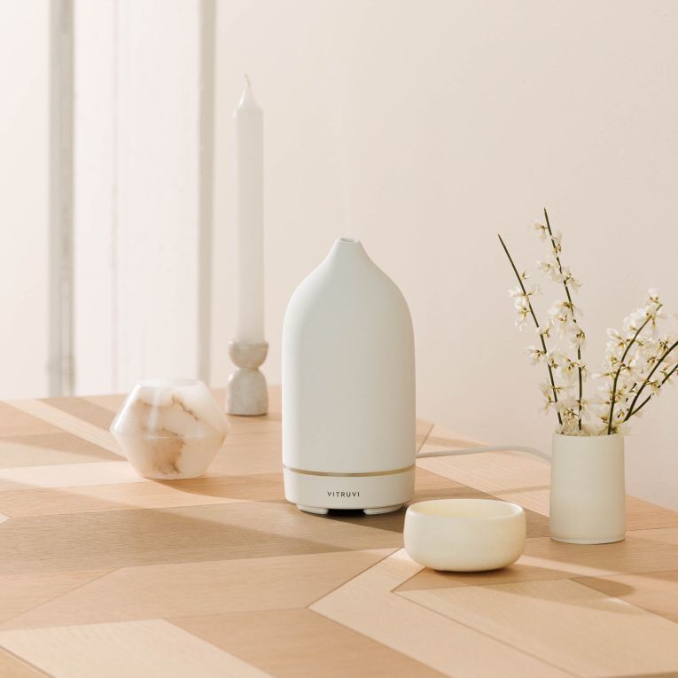 White diffuser on a table to scent the room