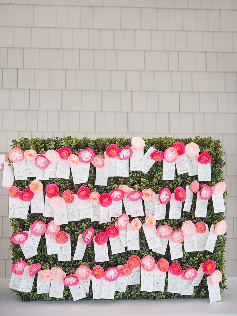 Preppy escort card display with paper flowers and blue calligraphy