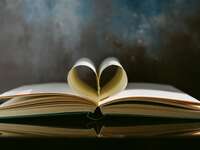 An open book with the pages folded into a heart shape