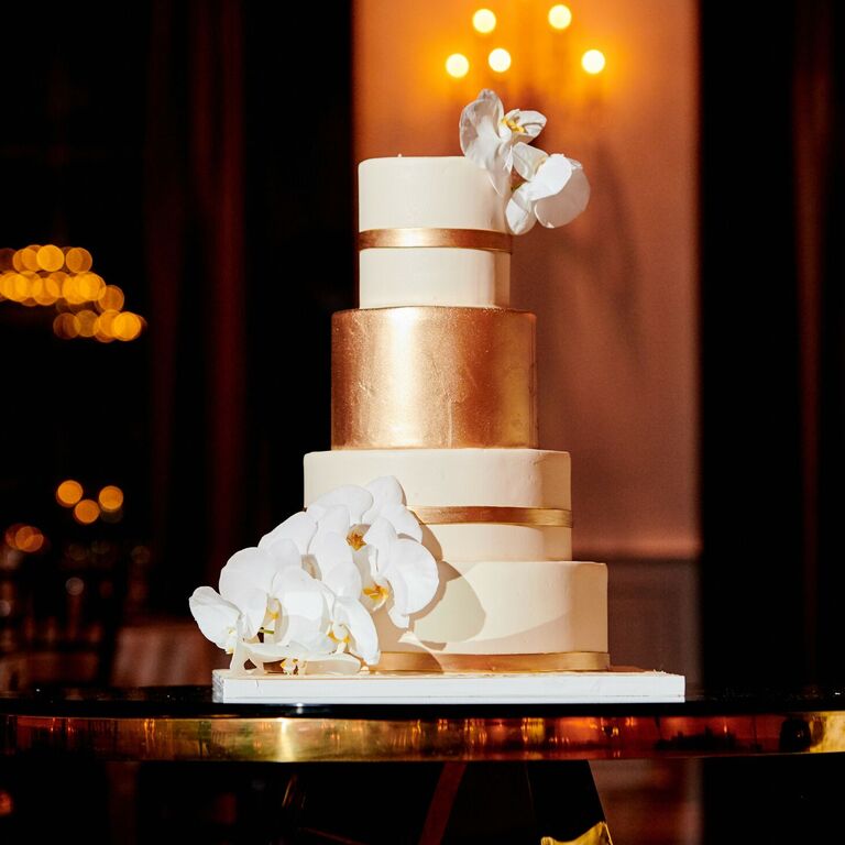 Gold-and-white wedding cake with orchids