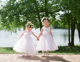 Flower girls wearing white holding hands