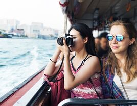 Couple riding on boat while one takes photos