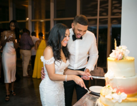 Couple cutting wedding cake together