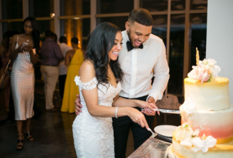 Couple cutting wedding cake together