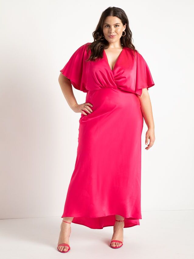 Model wears a pink silk gown with fluttery sleeves. 