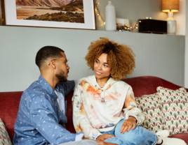 Couple sitting on couch talking to each other