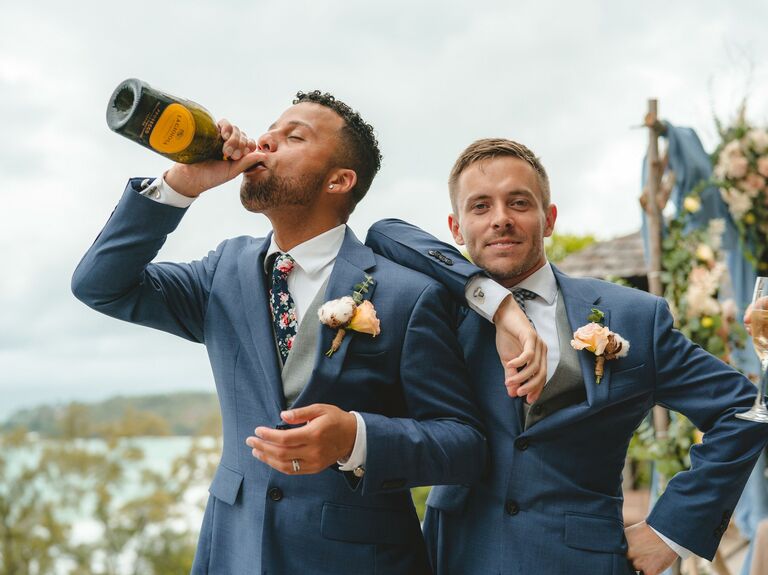 Couple drink champagne while posing for camera. 