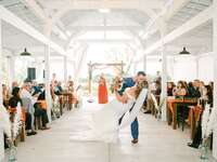 Happy newlyweds kissing in the middle of the aisle after exchanging their vows