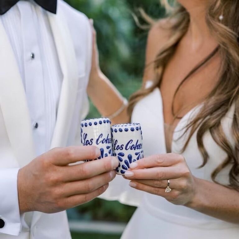 Happy couple using their personalized shot glasses on their big day