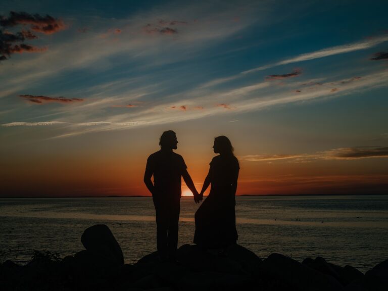 Couple poses at sunset for their summer engagement photo shoot. 