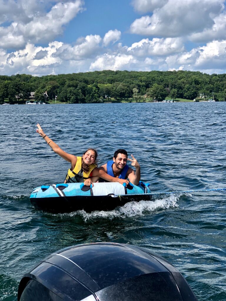 George and Julie's first encounter began in the summer of 2019 on an annual boat trip in Lake Geneva when they were randomly assigned to share a tube together. They had minutes to become cordially acquainted before they were challenged with the fight or flight response and the test of survival of the fittest. It was a beautiful sunny day, however, the waves were stronger than anticipated. George, ever the adventurer, in an effort to regain control and direction of the tube, almost gave Julie a concussion. When they reached the end of the boat trip, they laughed at their unexpected escapade not realizing this adventure would become a lifelong cherished memory.