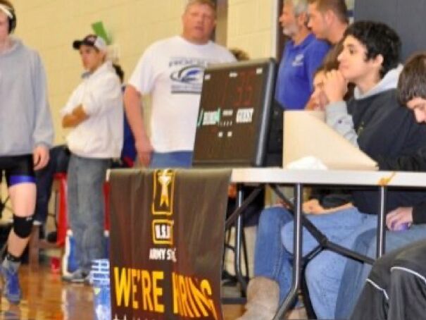Jonathan and Hannah (just right of Jonathan) at a scorer's table, working a wrestling tournament 