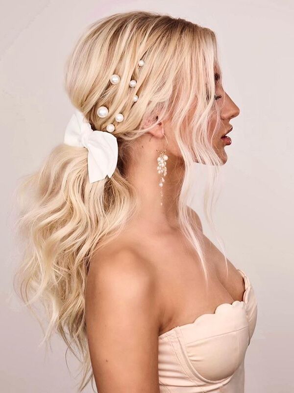 Low ponytail with hair bow and pearl bobby pins