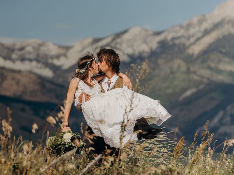 wedding couple kissing with montana mountain backdrop