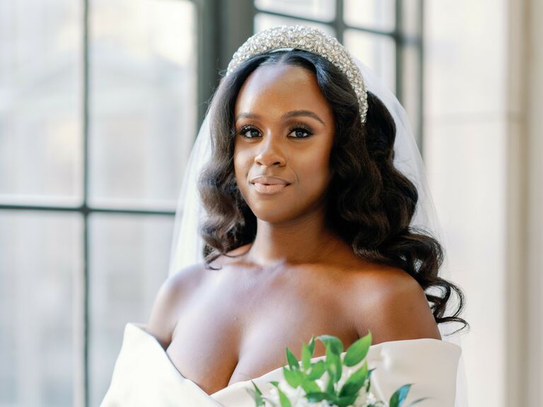 Bride wears a dazzling headband and her hair in long, loose waves. 