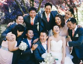 Mismatched wedding party with more groomsmen than bridesmaids laughing together with the bride and groom.