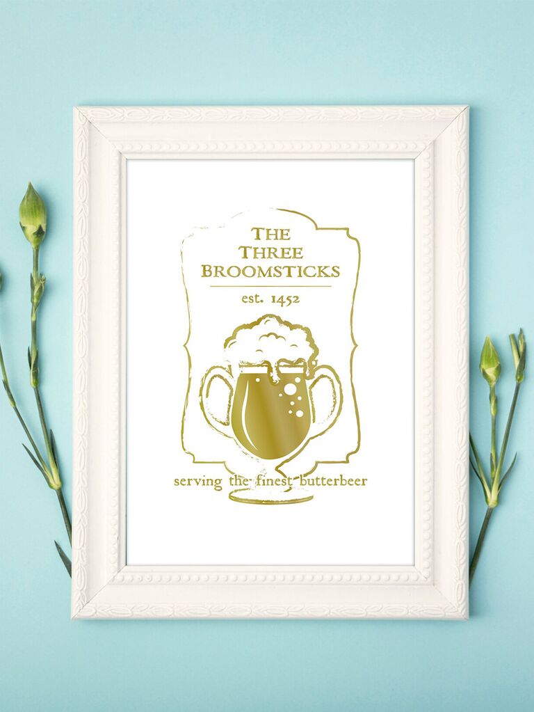 'The Three Broomsticks' and 'Serving the finest butterbeer' in gold minimalist HP font with butterbeer graphic and gilded border
