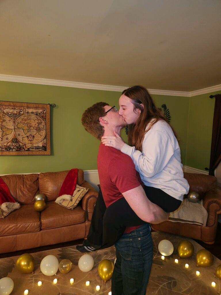 DJ surprised Sara by proposing to her on NYE after she had just got back from work. She thought DJ's family was just visiting to celebrate NYE with her family, but when she came home (covered in flour from the pizza counter) DJ had set out a heart made of balloons and tea-lights in her living room and popped the question!